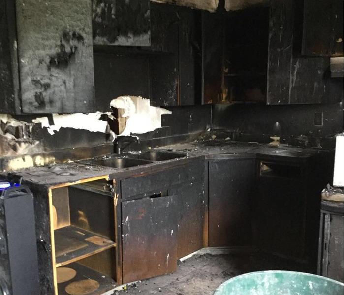 Charred and severely smoke damaged kitchen, in a local apartment. 