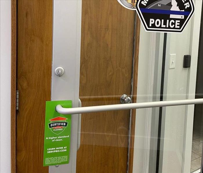 Glass door with a green sign that says clean