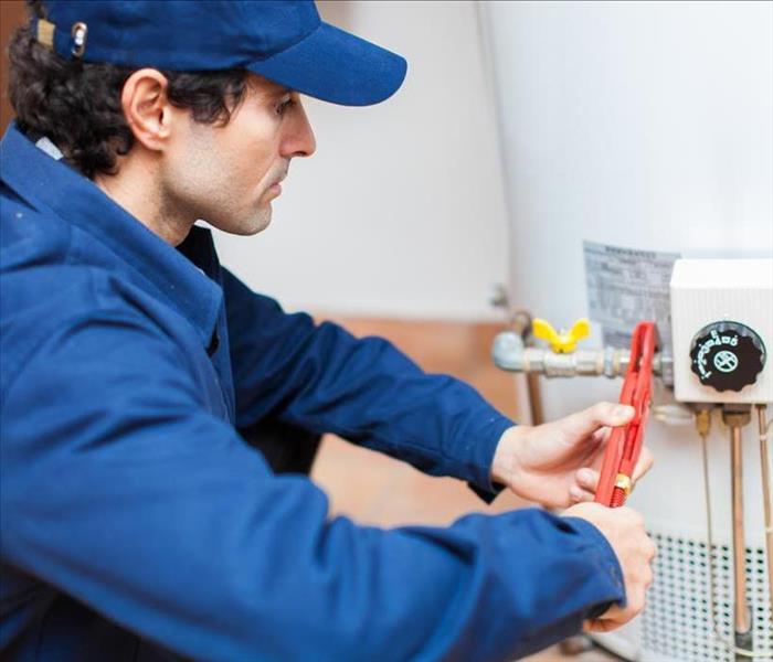 Image of a person working on a water heater